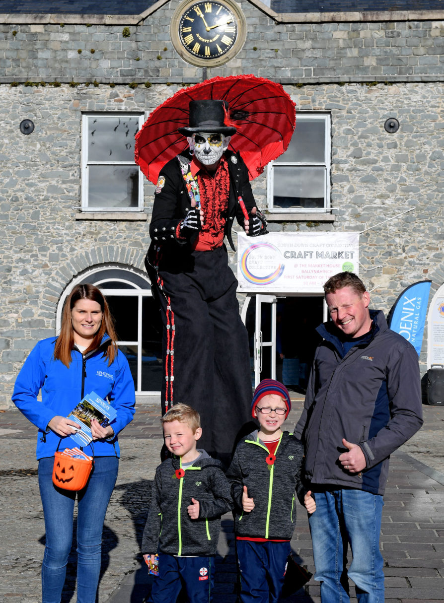 Danielle Dunbar, Phoenix Energy Marketing Manager and a spooky stilt walker conjure up Hallowe’en treats for Stephen Malcolmson and sons Oliver and Owen.