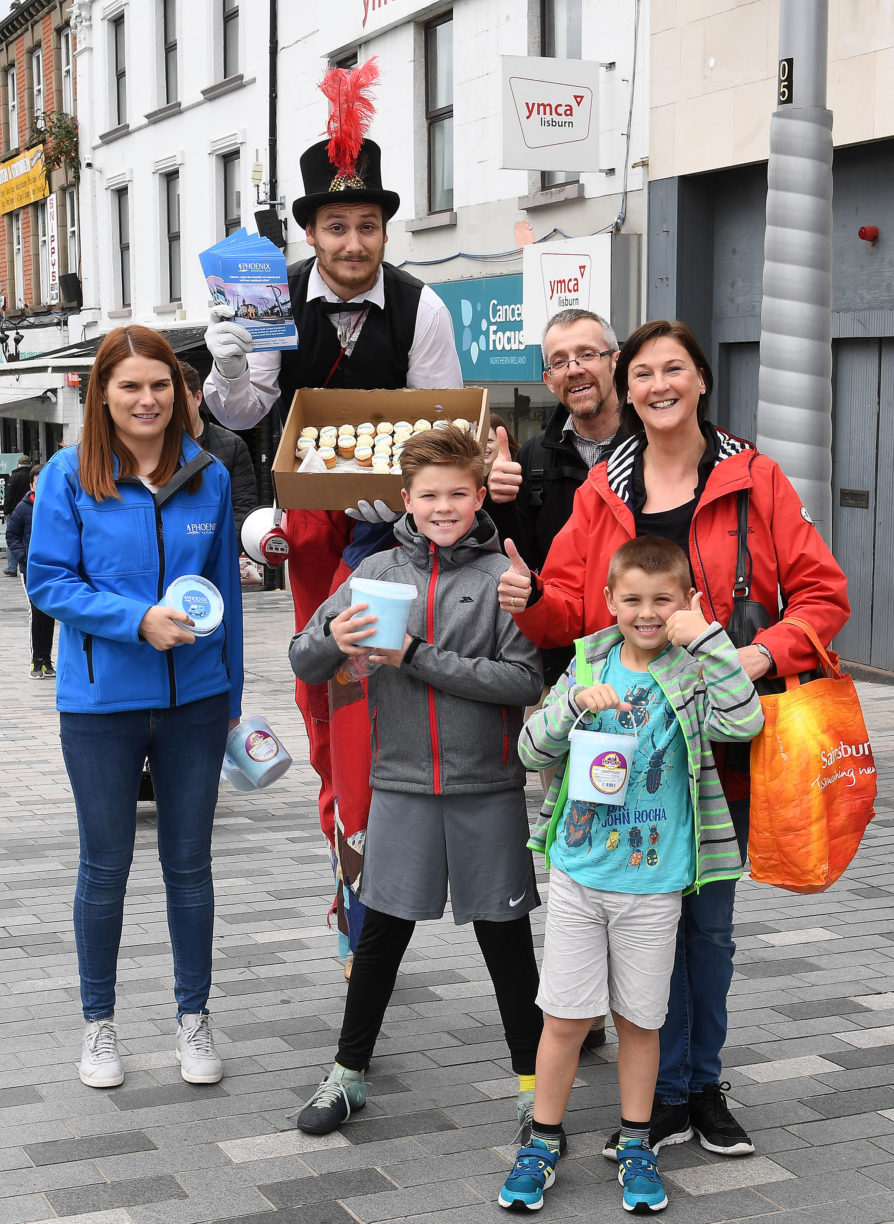 Phoenix Energy Marketing Manager, Danielle Dunbar, and stilt walker Dandy Ringmaster, are pictured delivering sweet treats to Archie and Laura and their children Barry and Morgan